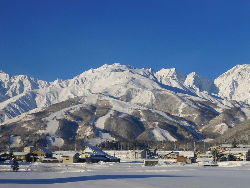 The snow-covered Hakuba mountains of the Japan Alps above a village in Hakuba